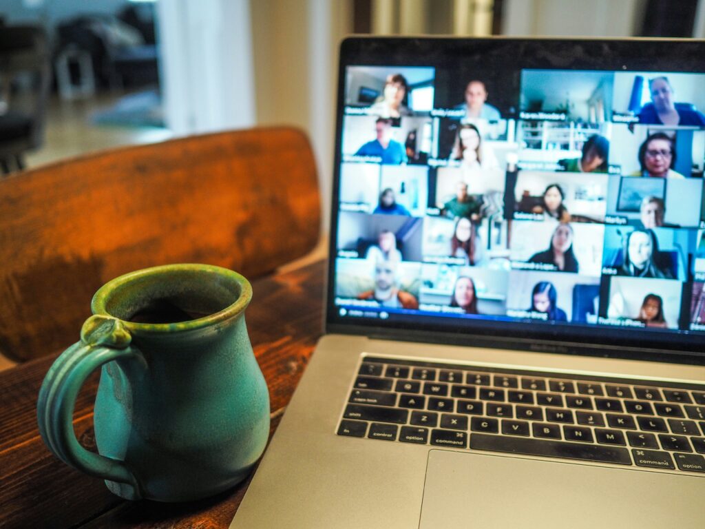  A laptop screen showing many faces on a group call